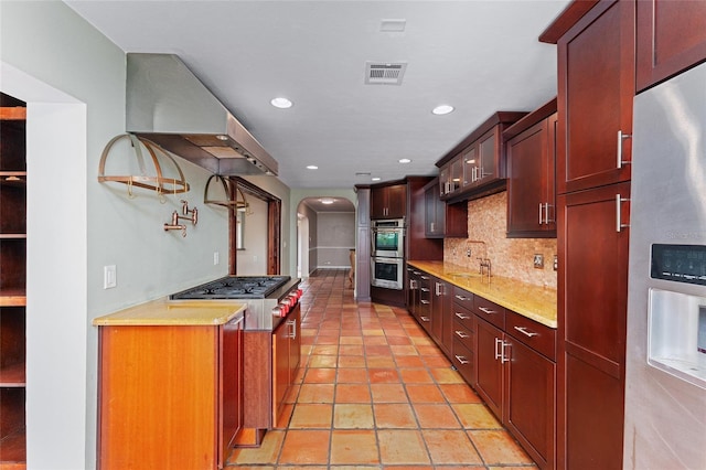 kitchen featuring sink, tasteful backsplash, appliances with stainless steel finishes, and exhaust hood