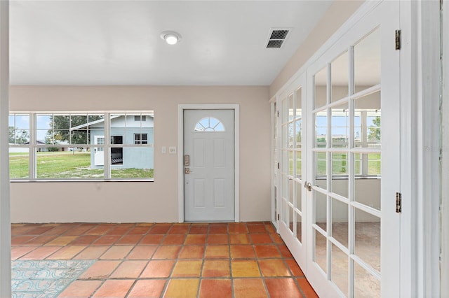 foyer with french doors, tile patterned flooring, and a wealth of natural light