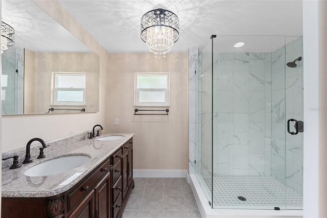 bathroom with a wealth of natural light, vanity, a shower with door, and an inviting chandelier