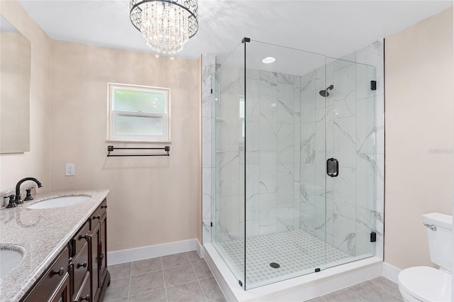 bathroom featuring tile patterned floors, toilet, a shower with shower door, a notable chandelier, and vanity