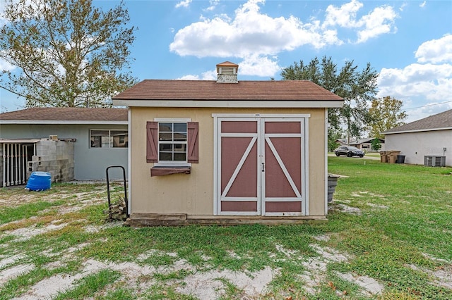 view of outbuilding featuring a lawn and cooling unit