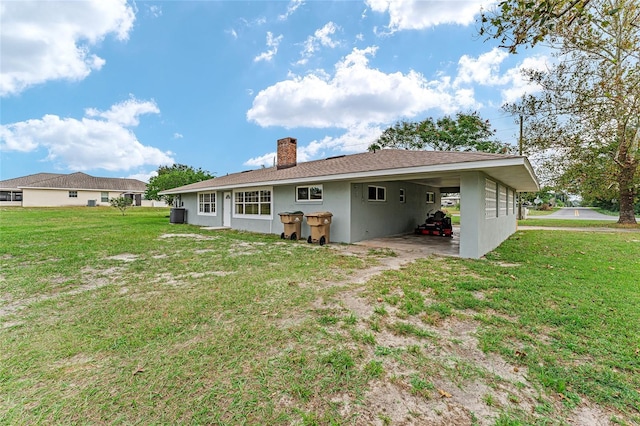 back of property featuring a carport and a lawn