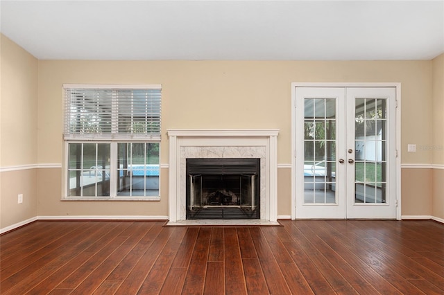 unfurnished living room featuring french doors, a fireplace, and dark hardwood / wood-style floors