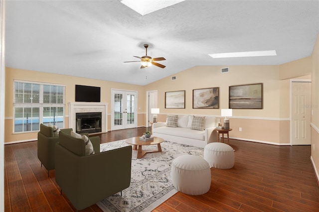 living room featuring a wealth of natural light, lofted ceiling, dark wood-type flooring, and french doors