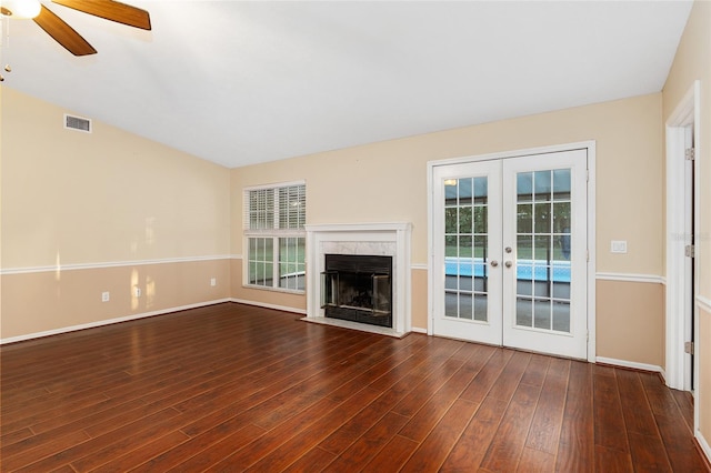 unfurnished living room featuring french doors, ceiling fan, dark wood-type flooring, and a premium fireplace