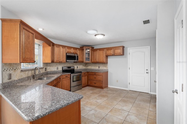 kitchen featuring kitchen peninsula, tasteful backsplash, stainless steel appliances, and sink