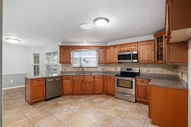 kitchen featuring tasteful backsplash, appliances with stainless steel finishes, sink, and kitchen peninsula