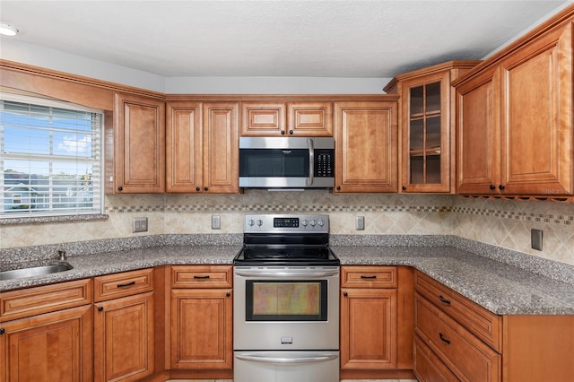 kitchen with decorative backsplash, stainless steel appliances, and stone countertops