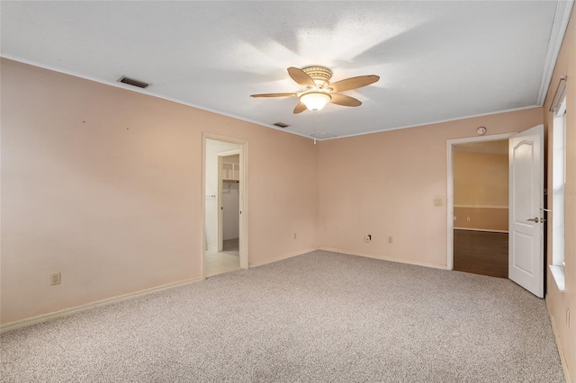 unfurnished room featuring light carpet, ornamental molding, and ceiling fan