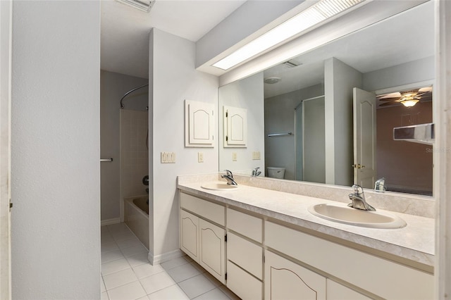 full bathroom with toilet, tiled shower / bath combo, vanity, and tile patterned flooring