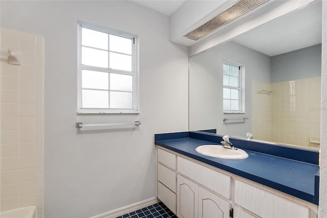 bathroom with vanity, tile patterned flooring, and tiled shower