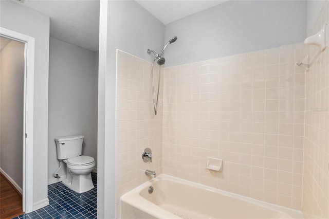 bathroom with toilet, tile patterned floors, and tiled shower / bath combo