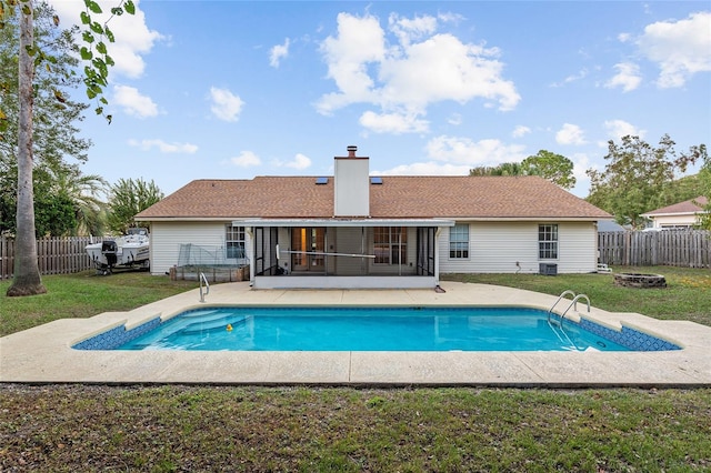 view of pool with a yard, a patio, and a sunroom