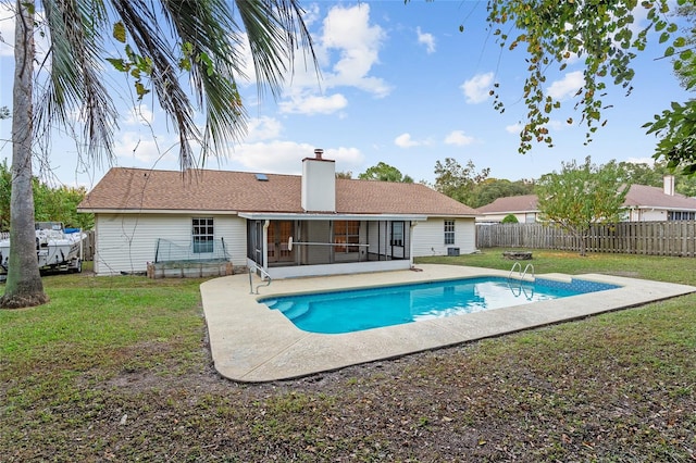 view of pool featuring a patio area, a lawn, and a sunroom