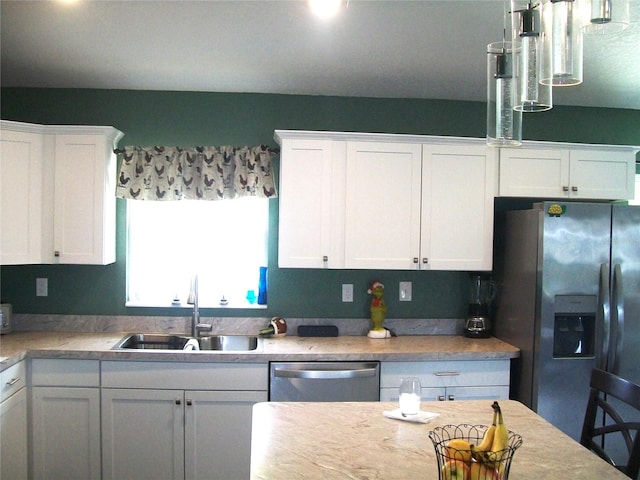 kitchen with appliances with stainless steel finishes, sink, and white cabinetry