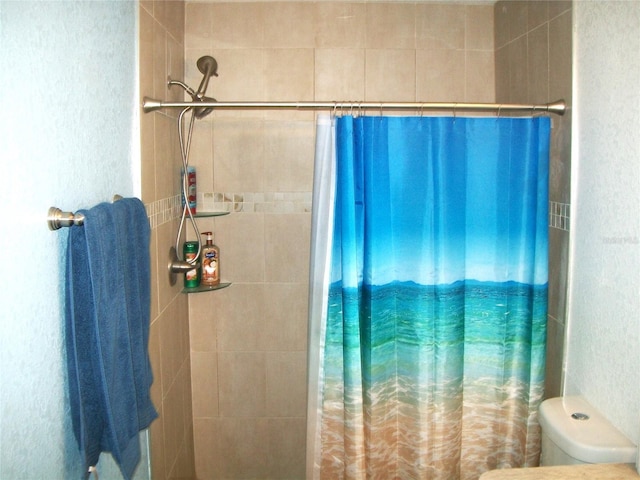 bathroom featuring curtained shower and toilet