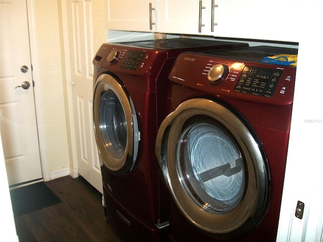 clothes washing area featuring independent washer and dryer, cabinets, and dark hardwood / wood-style flooring