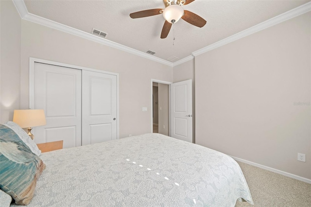 carpeted bedroom with ornamental molding, a textured ceiling, a closet, and ceiling fan