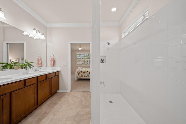 bathroom with vanity, crown molding, a tile shower, and tile patterned flooring