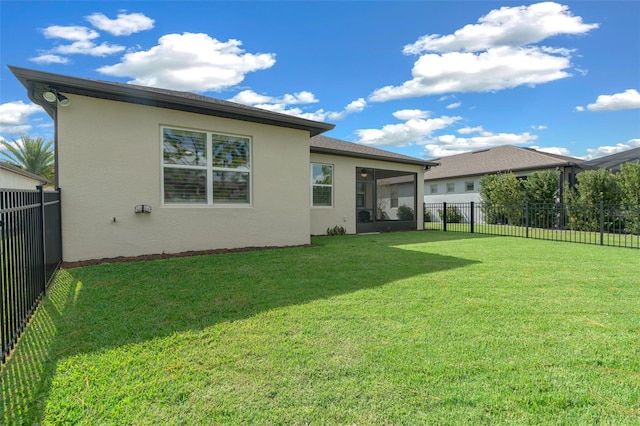 rear view of property with a sunroom and a lawn