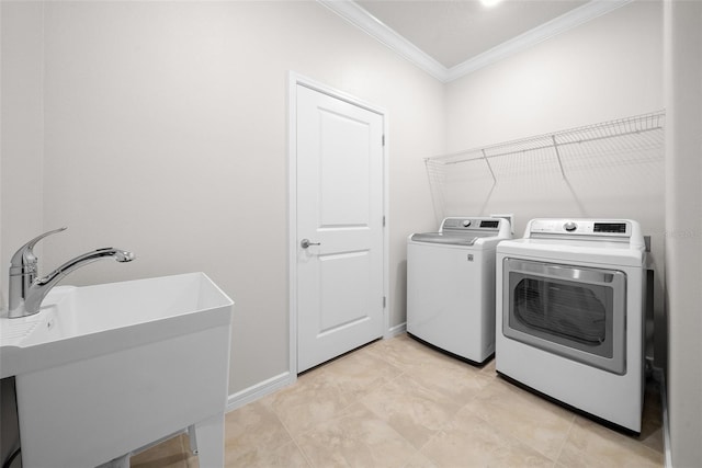 laundry room featuring sink, crown molding, and washing machine and clothes dryer