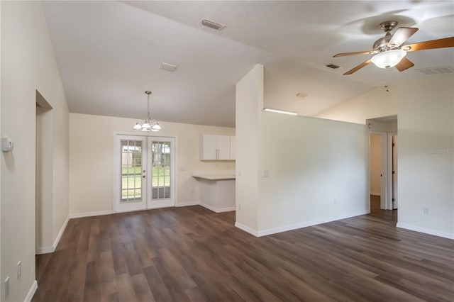 unfurnished living room with dark hardwood / wood-style flooring, french doors, ceiling fan with notable chandelier, and vaulted ceiling