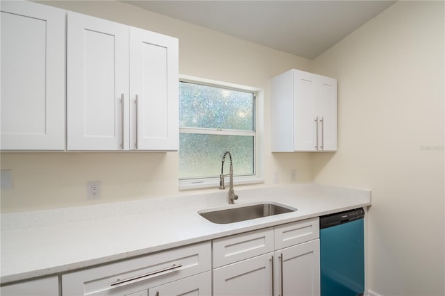 kitchen featuring light stone counters, sink, stainless steel dishwasher, and white cabinets