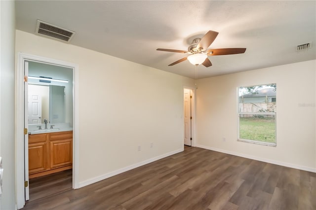 empty room with sink, ceiling fan, a textured ceiling, and dark hardwood / wood-style flooring