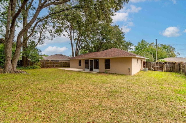 back of property featuring a yard, cooling unit, and a patio area