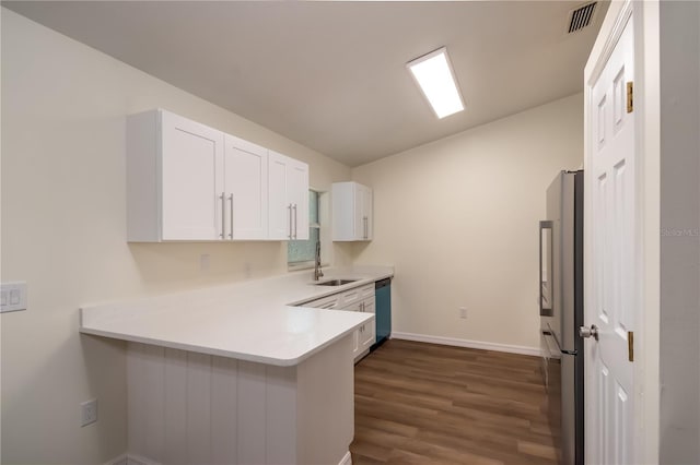 kitchen with stainless steel appliances, kitchen peninsula, sink, and white cabinets