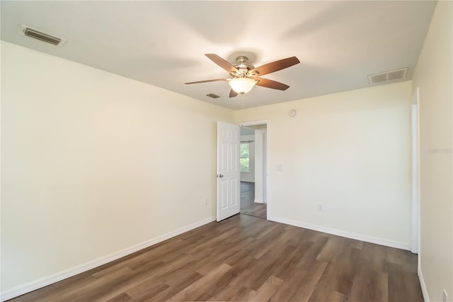 empty room with dark hardwood / wood-style flooring and ceiling fan