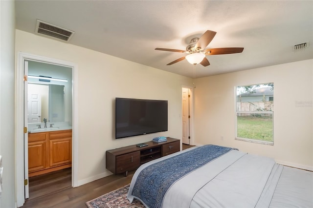 bedroom featuring sink, ensuite bath, dark hardwood / wood-style floors, and ceiling fan