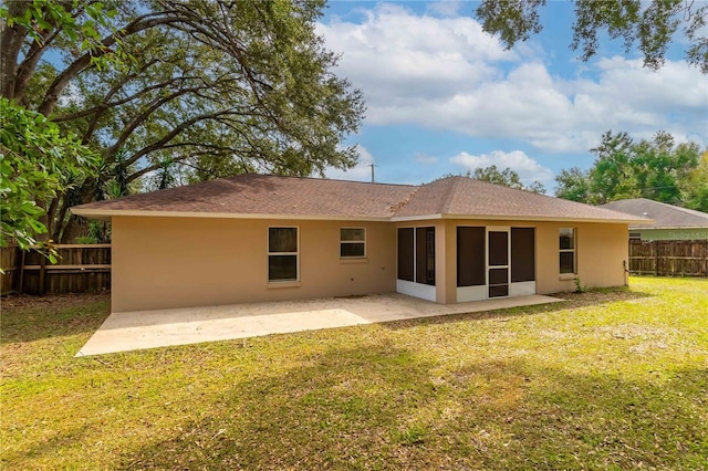 rear view of house with a sunroom, a yard, and a patio