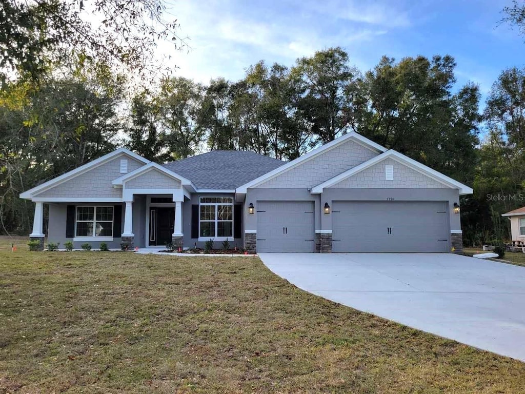 craftsman house featuring a garage and a front yard