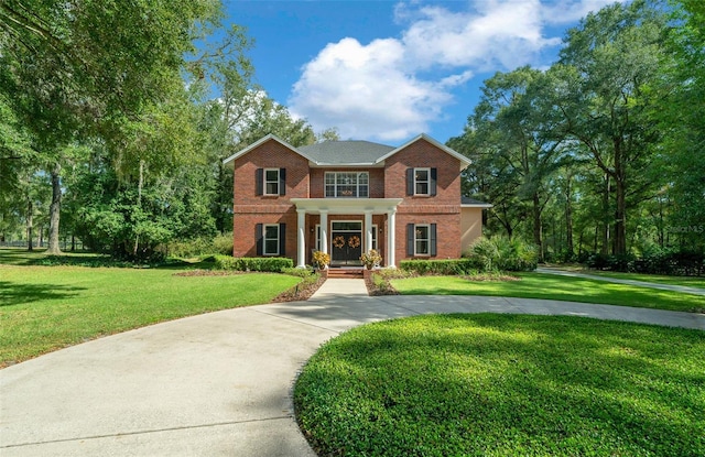 colonial-style house featuring covered porch and a front lawn