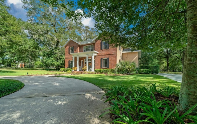 colonial inspired home with a front lawn