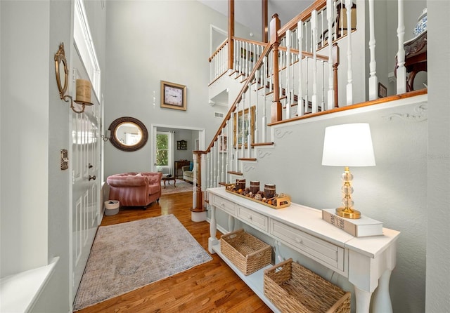 entryway featuring light hardwood / wood-style floors and a towering ceiling