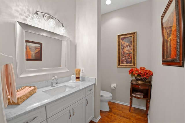 bathroom featuring vanity, wood-type flooring, and toilet