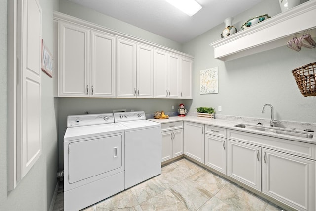 washroom with cabinets, sink, and washer and clothes dryer