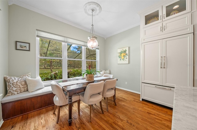 dining area with crown molding and light hardwood / wood-style flooring