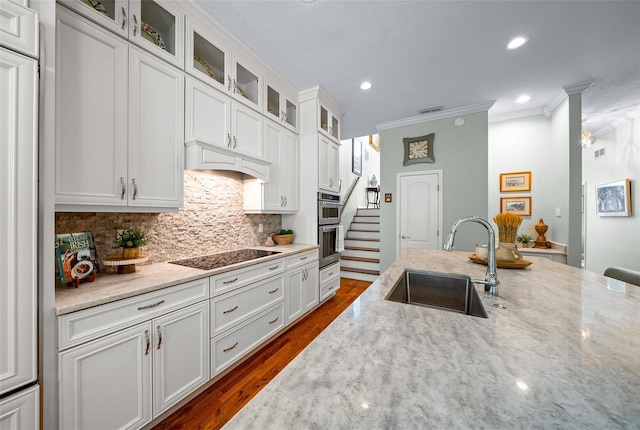 kitchen with white cabinetry, ornamental molding, sink, and black electric cooktop