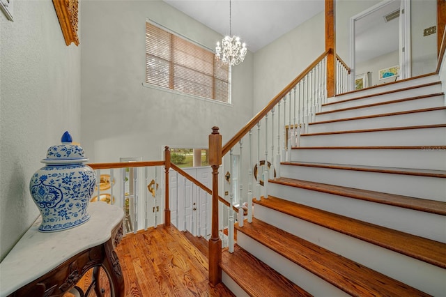 stairs featuring a notable chandelier and hardwood / wood-style floors