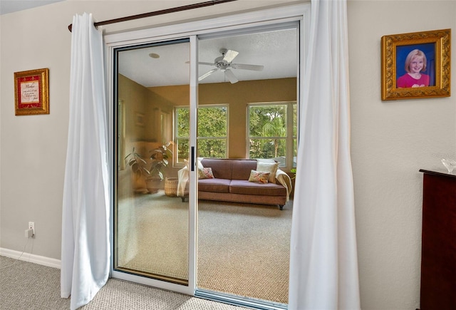 doorway with carpet floors and ceiling fan