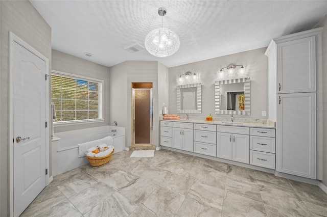 bathroom featuring vanity, a notable chandelier, a textured ceiling, and separate shower and tub