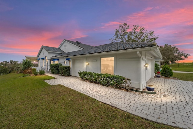 exterior space with a garage and a lawn