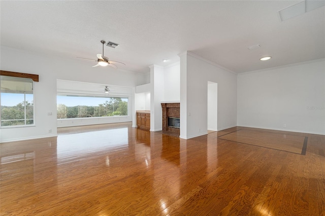 unfurnished living room featuring ceiling fan, wood-type flooring, and crown molding