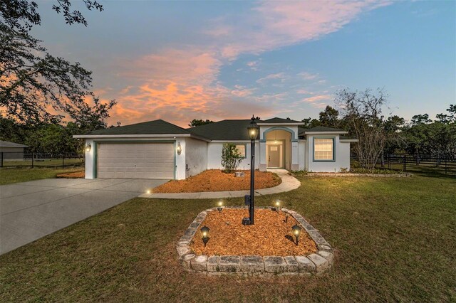 ranch-style house featuring a yard and a garage