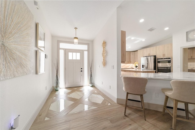 interior space with lofted ceiling and light hardwood / wood-style floors