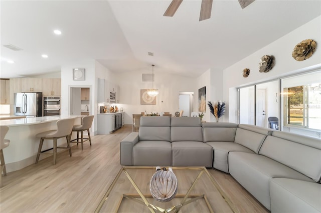 living room featuring vaulted ceiling, light wood-type flooring, and ceiling fan