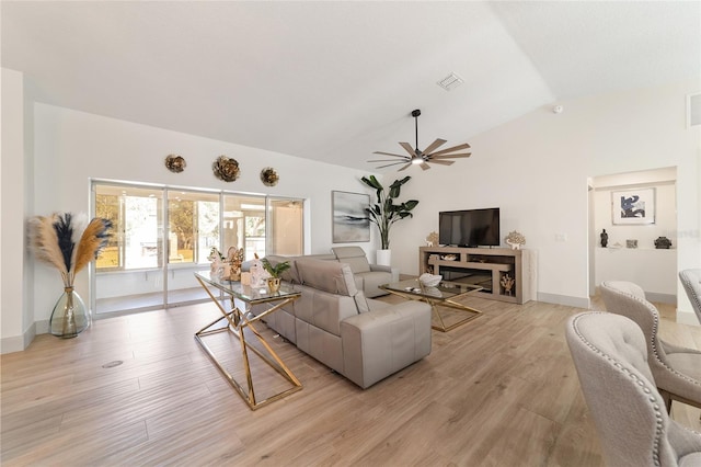 living room with light hardwood / wood-style floors, ceiling fan, and vaulted ceiling